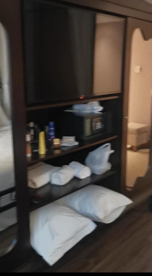 Buona Vitta Gramado Resort & Spa By Gramado Parks ภายนอก รูปภาพ The photo shows a piece of furniture, likely a shelving unit or cabinet, with several items on it. There is a television mounted on top. Below the TV, there is a microwave and a small safe. The shelves contain various toiletries and personal care pro