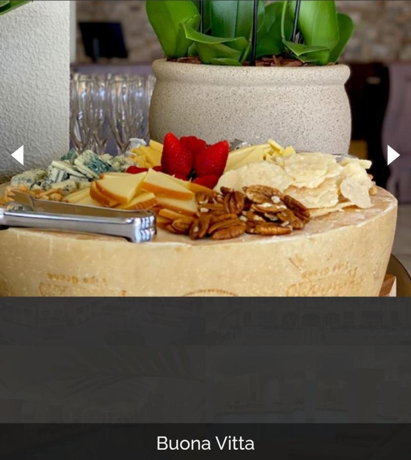 Buona Vitta Gramado Resort & Spa By Gramado Parks ภายนอก รูปภาพ The photo displays a beautiful cheese platter. It features a large round cheese wheel as the base, surrounded by various types of cheeses including soft and hard varieties. There are also some crackers or crisps, along with nuts, particularly pecans.