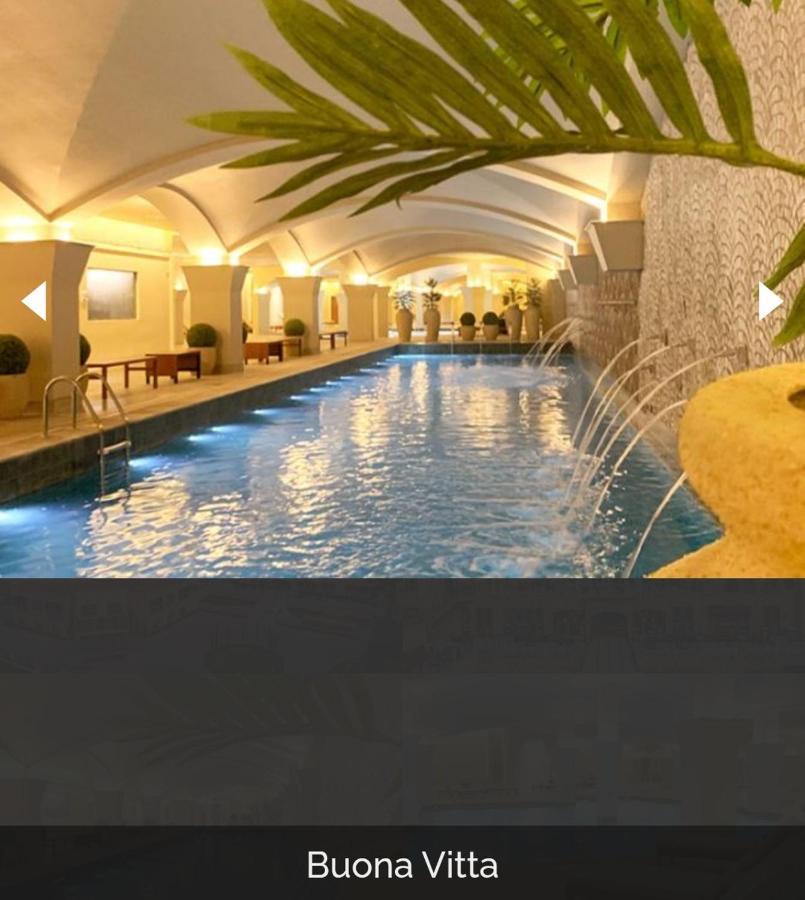 Buona Vitta Gramado Resort & Spa By Gramado Parks ภายนอก รูปภาพ The photo depicts an elegant indoor swimming pool area. The pool is illuminated with lights along its edge, and there are gentle water features creating a calming atmosphere. The ceiling has an arched design, and the space is decorated with plants an