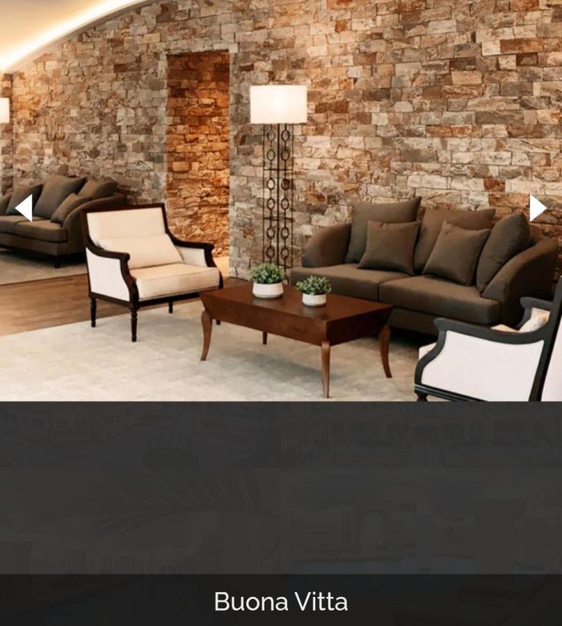 Buona Vitta Gramado Resort & Spa By Gramado Parks ภายนอก รูปภาพ The image shows a stylish living room setting. There are two sofas: one is a dark brown color, and the other is a cream color with dark wooden accents. In the center, there is a wooden coffee table with a smooth finish and decorative plants on top. T