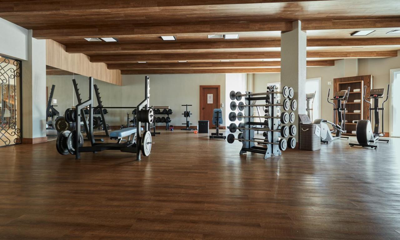 Buona Vitta Gramado Resort & Spa By Gramado Parks ภายนอก รูปภาพ The photo shows a spacious gym with a wooden floor and wooden ceiling beams. Various pieces of gym equipment are visible, including weight benches and racks with weights. On one side, there are free weights organized on a rack, while other equipment 