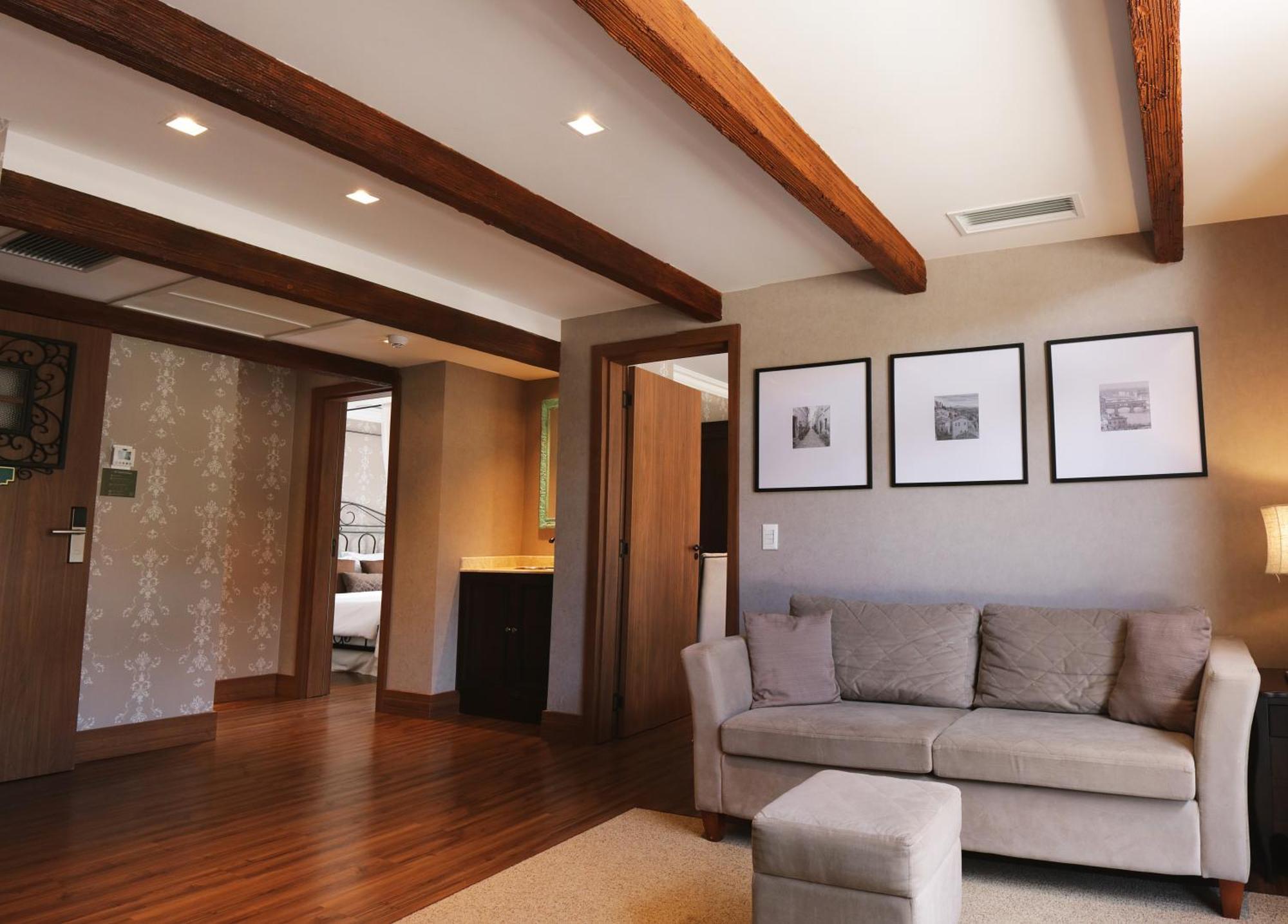 Buona Vitta Gramado Resort & Spa By Gramado Parks ภายนอก รูปภาพ The photo showcases a modern living space with a cozy and well-lit atmosphere. There are wooden beams visible on the ceiling, adding a rustic touch. The flooring is a warm-toned wood, contributing to the inviting feel of the room. 

On one side, ther
