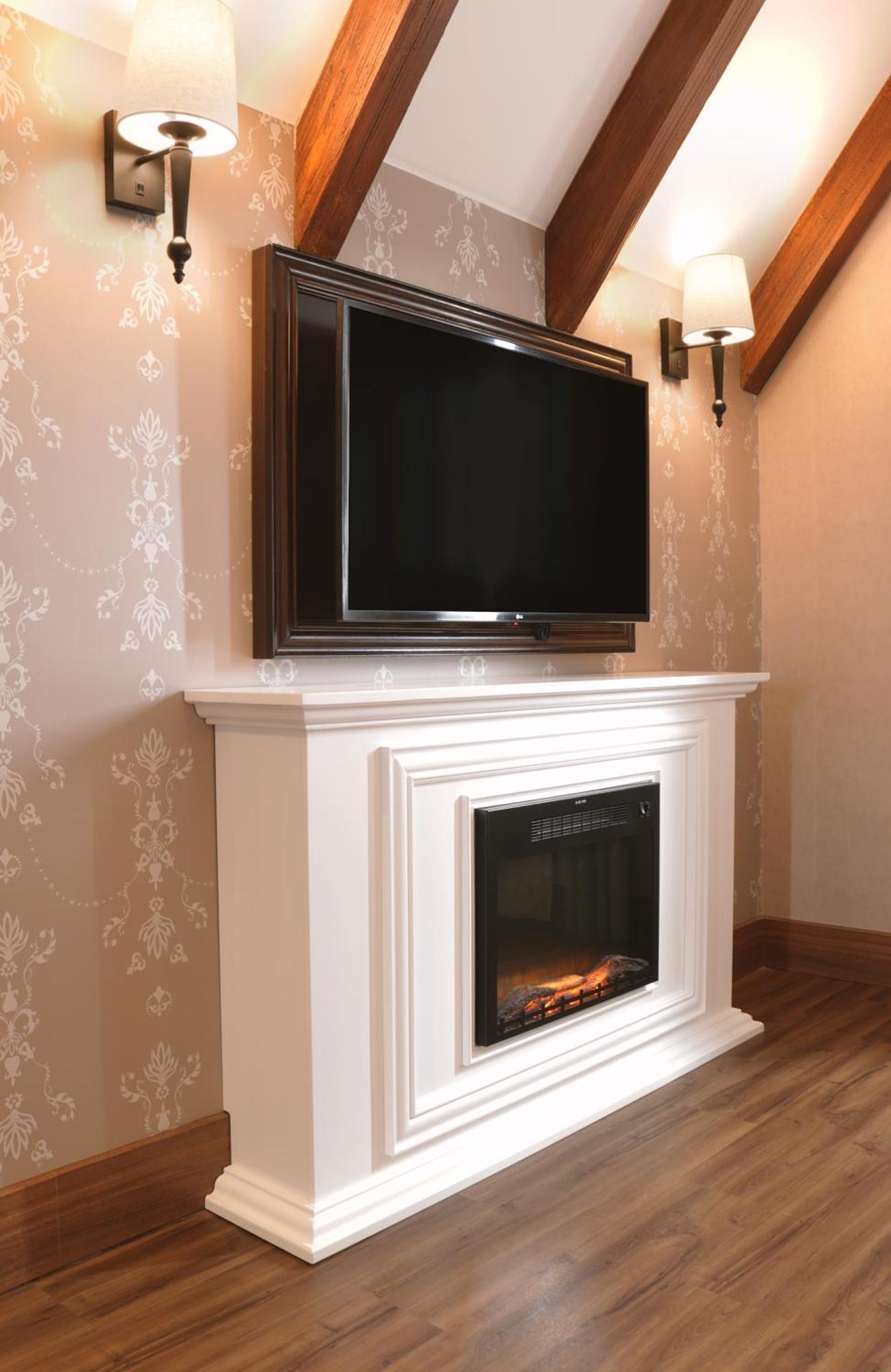 Buona Vitta Gramado Resort & Spa By Gramado Parks ภายนอก รูปภาพ The image shows a modern living room setup featuring a white mantel with an electric fireplace. Above the mantel, there is a large flat-screen television mounted on the wall. The fireplace has a glass front and displays a realistic flame effect, crea